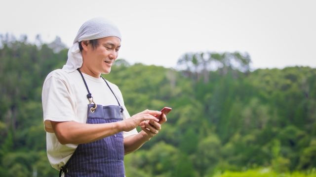 天気をスマホでチェックする男性